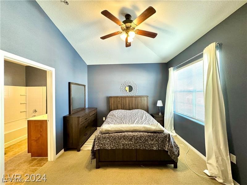 8777 West Maule Avenue, Unit 2103 Las Vegas, NV 89148 - Photo 14 of 33 Carpeted bedroom with lofted ceiling, a ceiling fan, and ensuite bathroom
