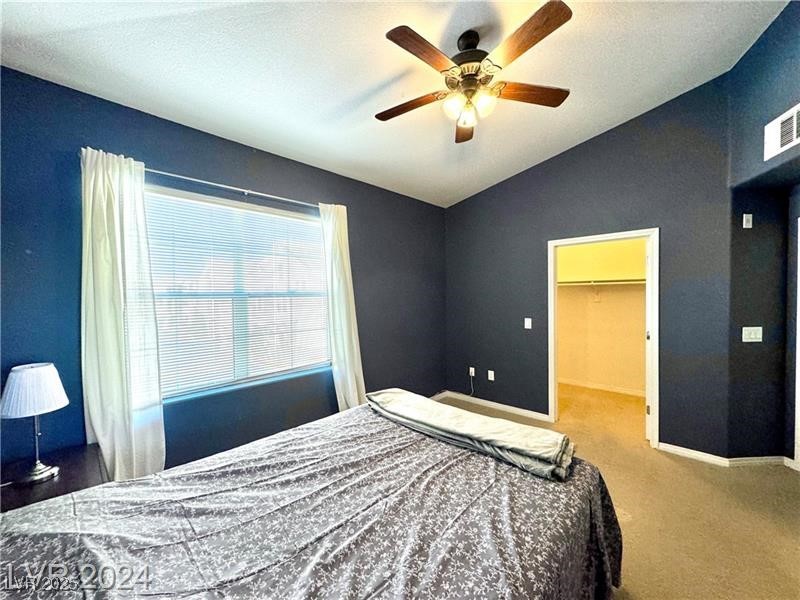 8777 West Maule Avenue, Unit 2103 Las Vegas, NV 89148 - Photo 17 of 33 Bedroom featuring vaulted ceiling, a walk in closet, carpet flooring, and a ceiling fan