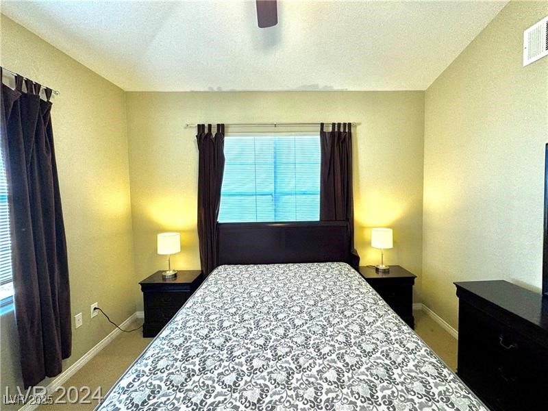 8777 West Maule Avenue, Unit 2103 Las Vegas, NV 89148 - Photo 23 of 33 Bedroom featuring a ceiling fan, light carpet, and a textured ceiling