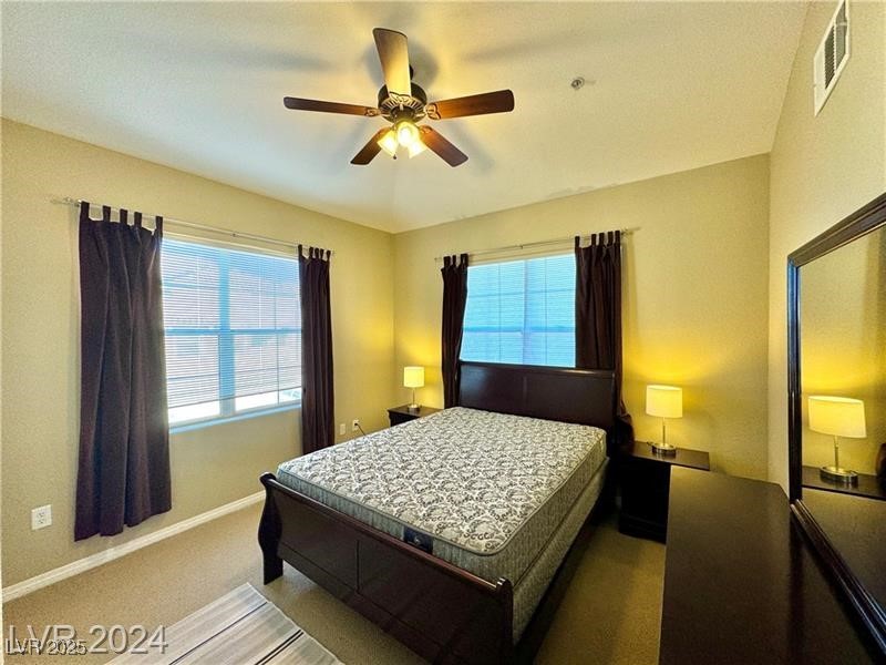 8777 West Maule Avenue, Unit 2103 Las Vegas, NV 89148 - Photo 28 of 33 Carpeted bedroom featuring ceiling fan and multiple windows