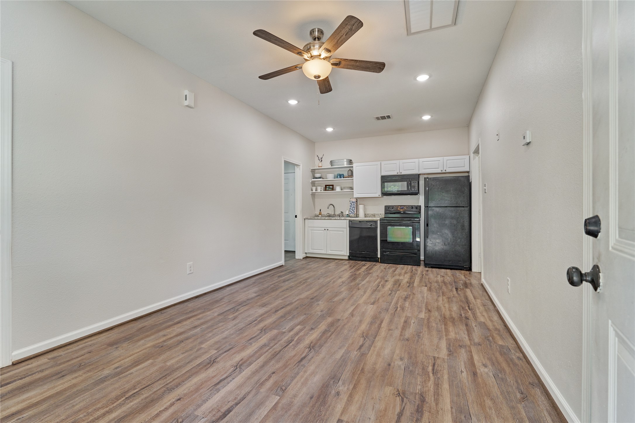 18147 Firepine Lane Montgomery, TX 77316 - Photo 6 of 25 wooden floor in an empty room with a kitchen