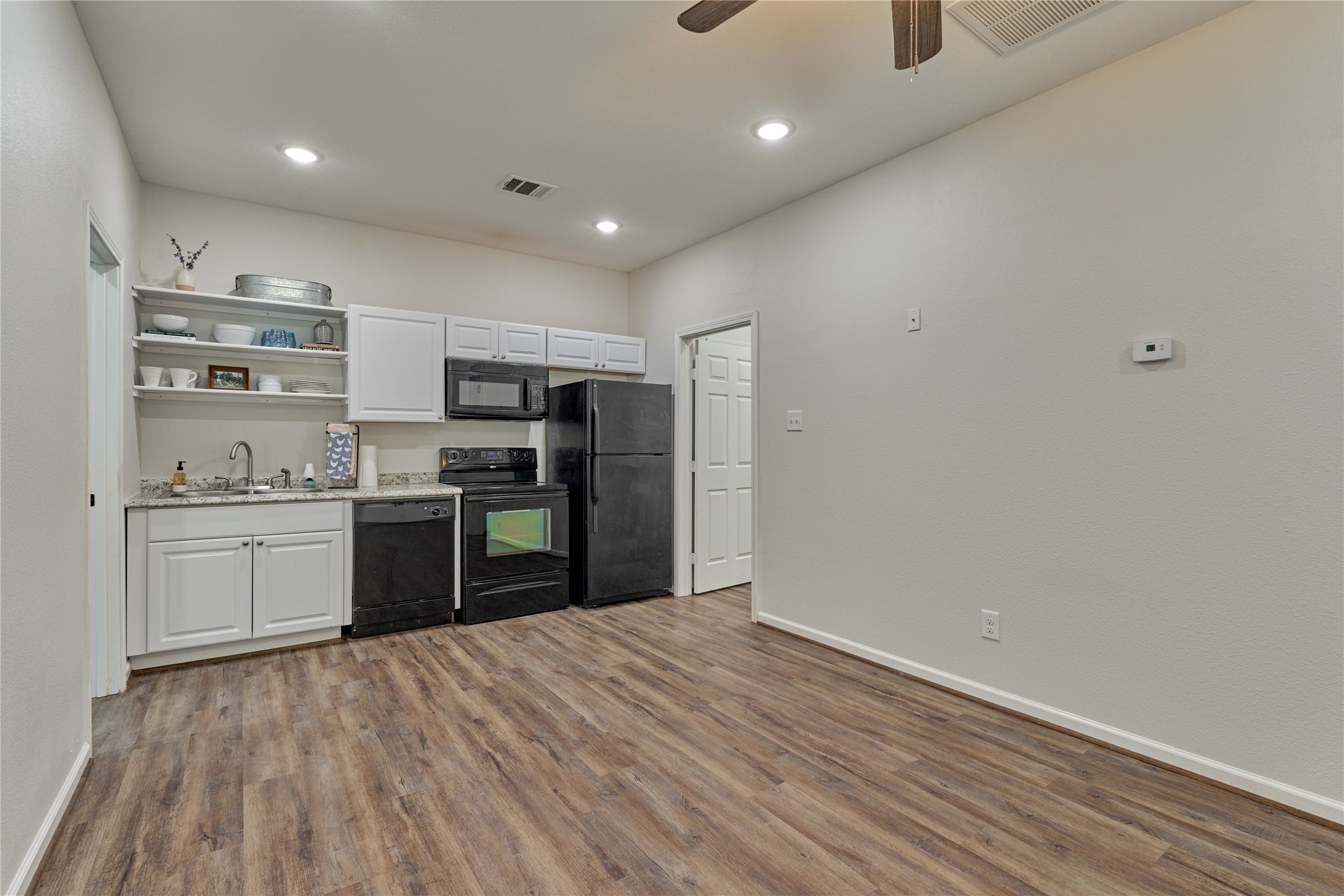 18147 Firepine Lane Montgomery, TX 77316 - Photo 9 of 25 a kitchen with a refrigerator and white cabinets