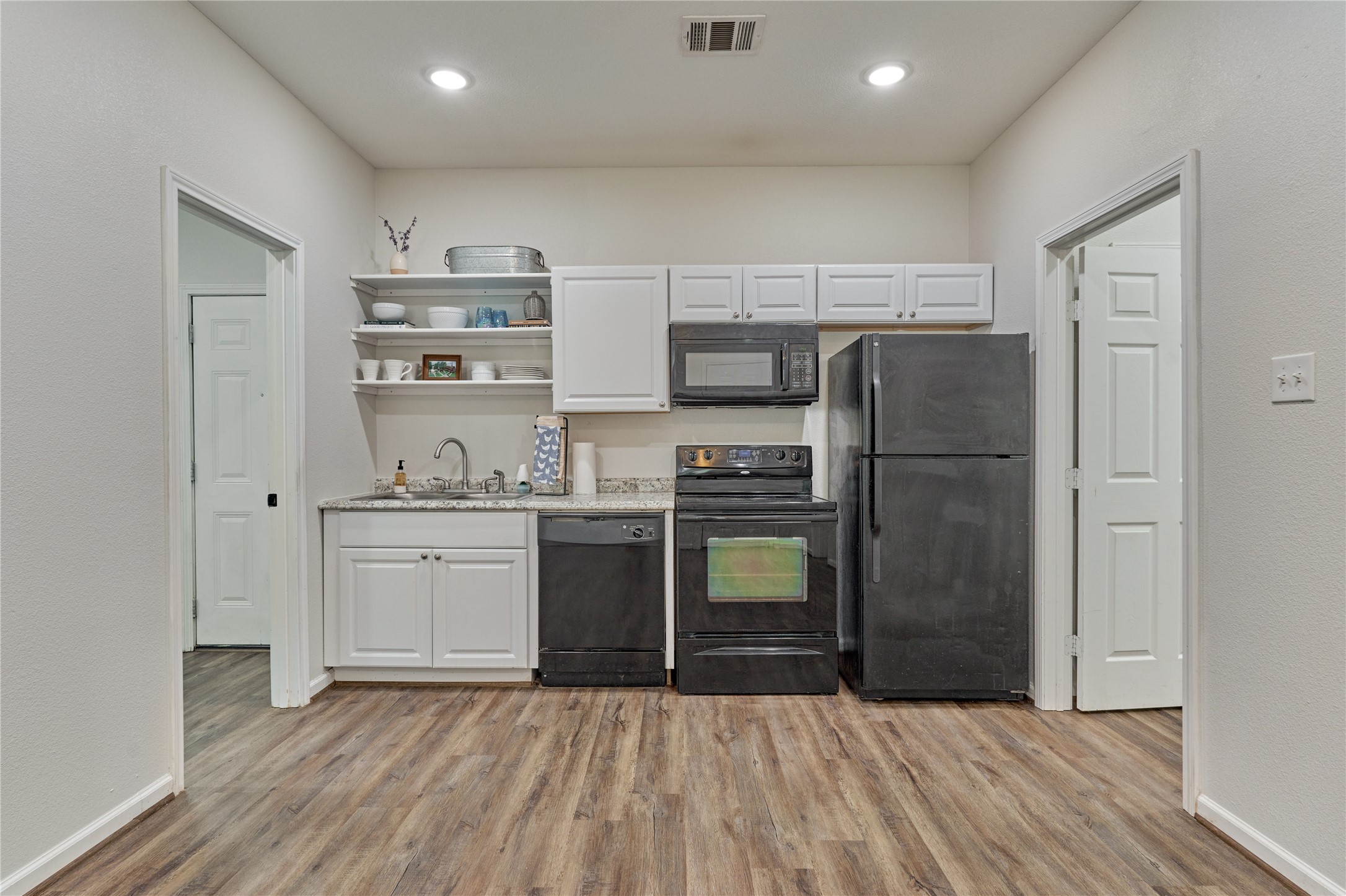 18147 Firepine Lane Montgomery, TX 77316 - Photo 10 of 25 a kitchen with granite countertop a refrigerator and a stove top oven