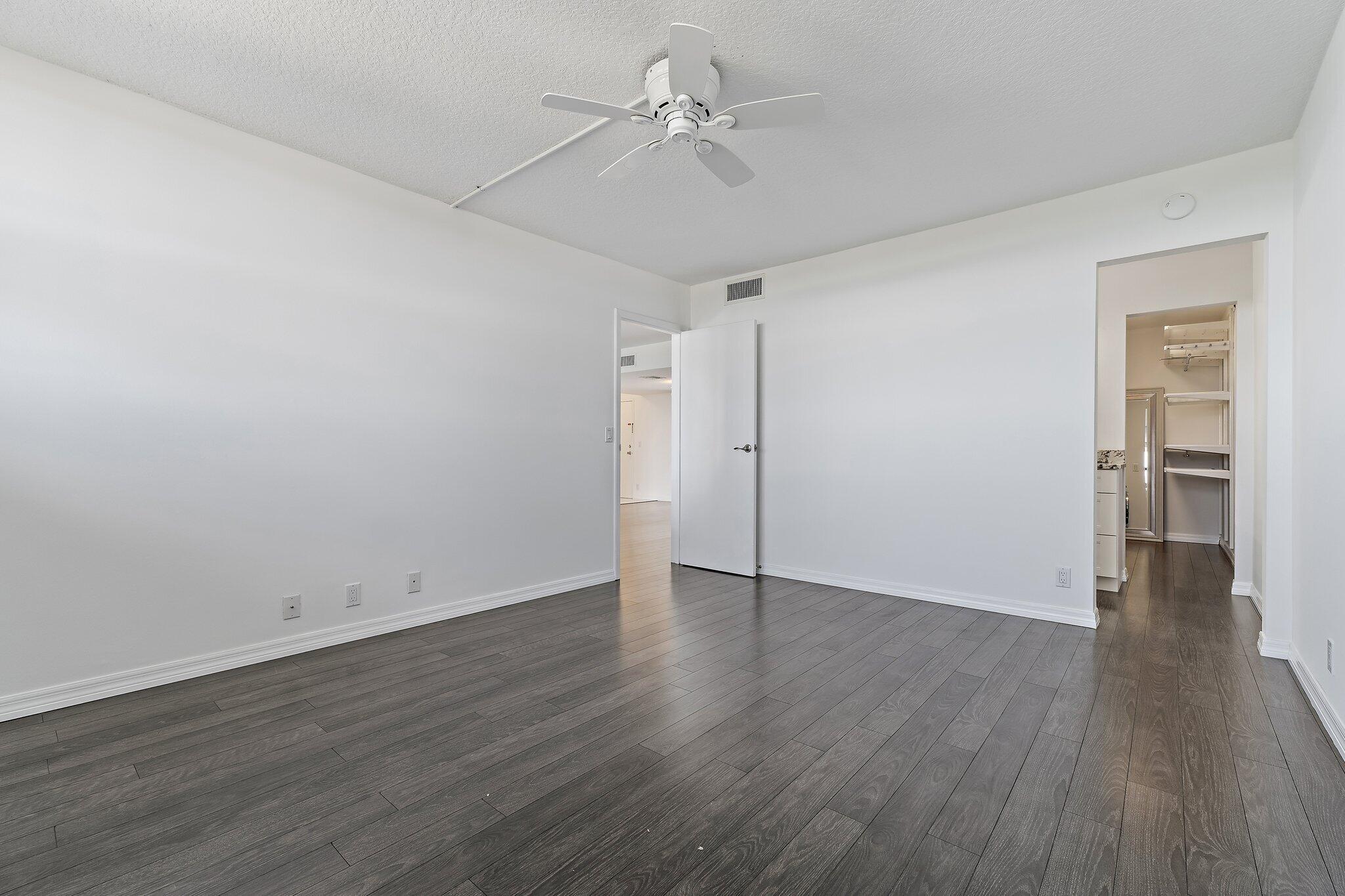 336 Golfview Road, Unit 719 North Palm Beach, FL 33408 - Photo 23 of 72 an empty room with wooden floor ceiling fan and windows