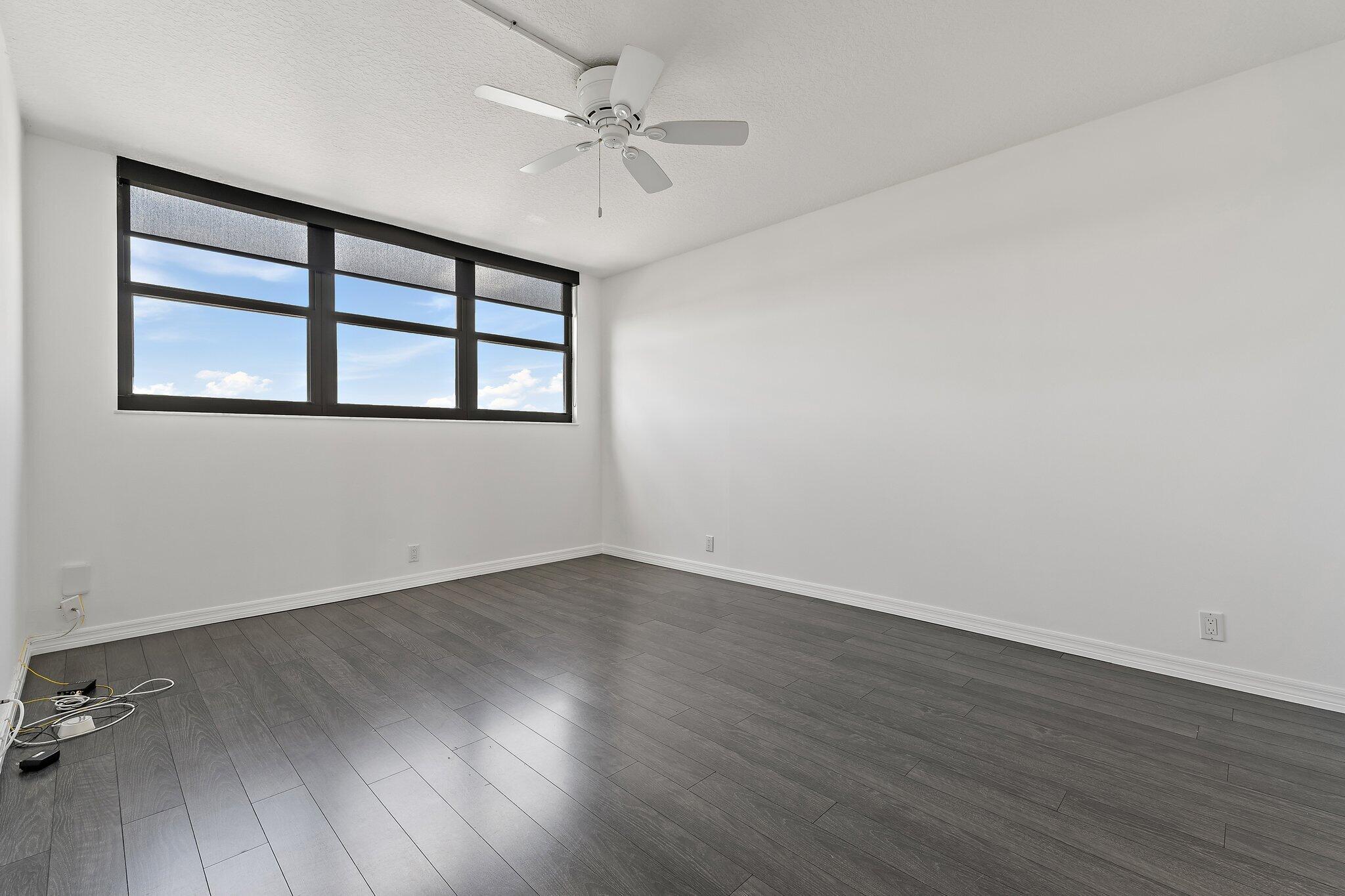 336 Golfview Road, Unit 719 North Palm Beach, FL 33408 - Photo 24 of 72 an empty room with wooden floor ceiling fan and windows