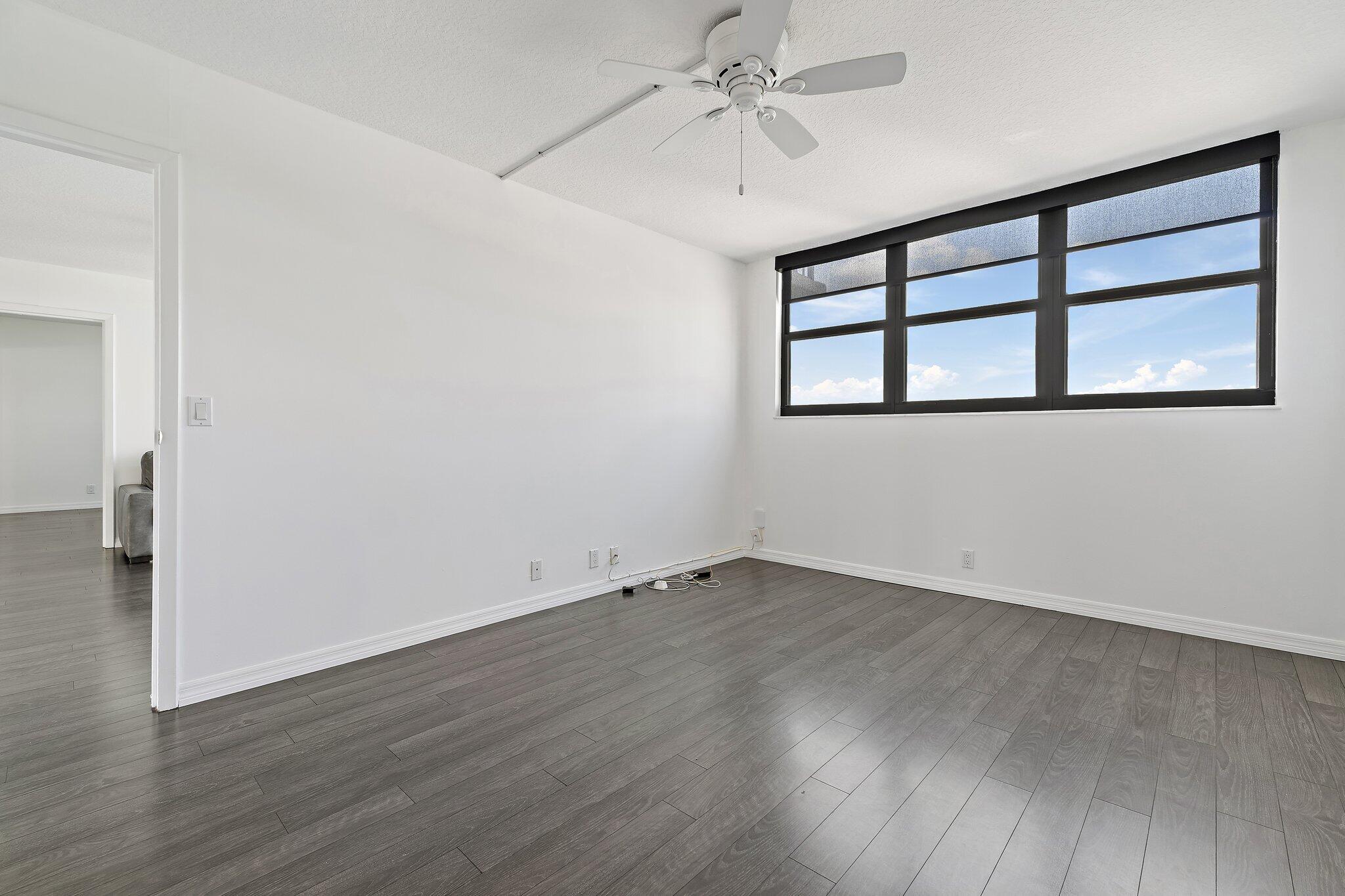 336 Golfview Road, Unit 719 North Palm Beach, FL 33408 - Photo 25 of 72 an empty room with wooden floor chandelier fan and windows