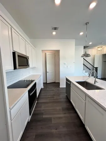 a kitchen with sink a microwave and stove