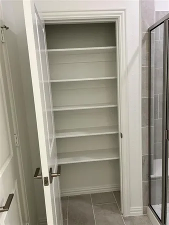 a view of walk in closet with empty racks