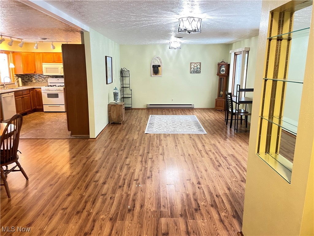 1381 Robb Road Conneaut, OH 44030 - Photo 7 of 50 Dining area featuring a textured ceiling, light wood-style floors, track lighting, and baseboard heating