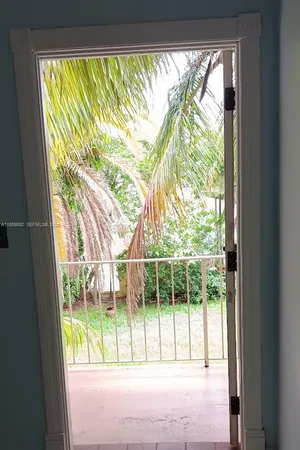 a view of a glass door with a yard from a window