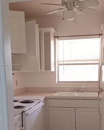 a kitchen with a sink cabinets and window