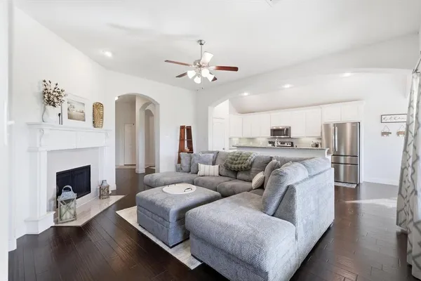 a living room with furniture fireplace and kitchen view