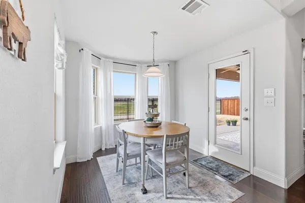 a dining room with furniture window and wooden floor
