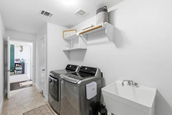 a utility room with sink dryer and washer