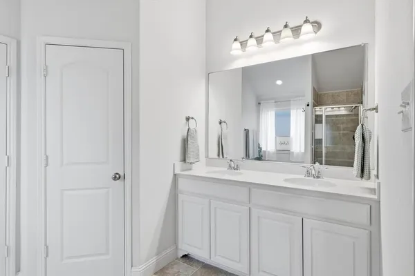 a bathroom with a double vanity sink and a mirror