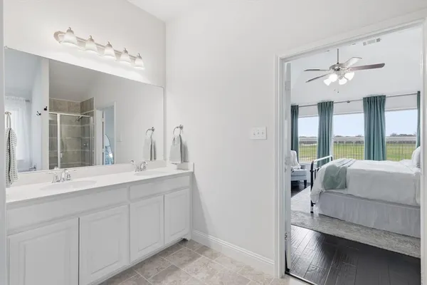 a en suite bathroom with a double vanity sink a large mirror and shower