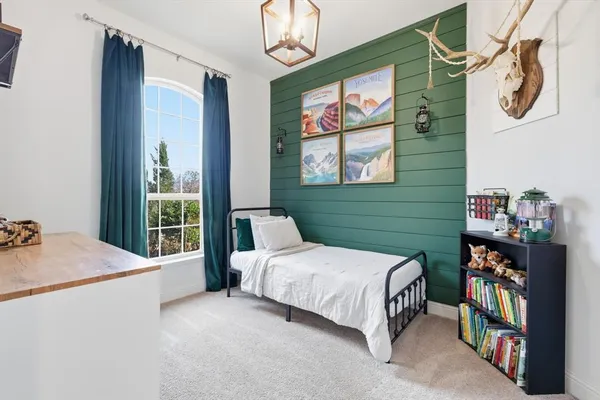 a bedroom with a bed a bookshelf and a window