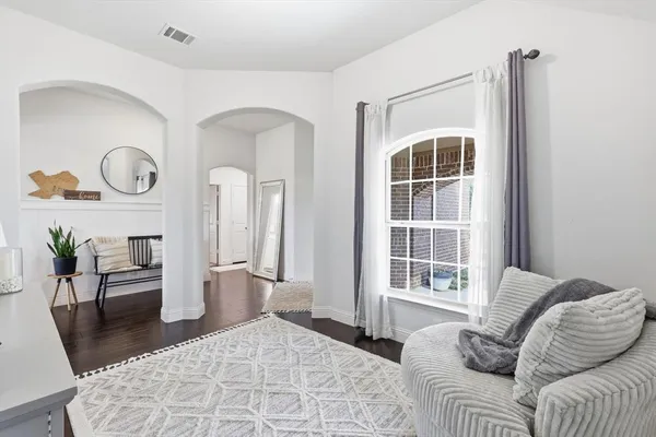 a living room with furniture a window and wooden floor