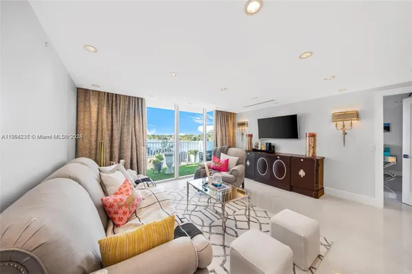 a living room with furniture a flat screen tv and a window