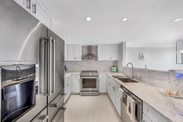 a kitchen that has a sink and a stove with wooden floor