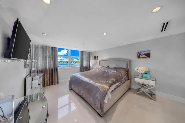 a spacious bedroom with a bed and wooden floor