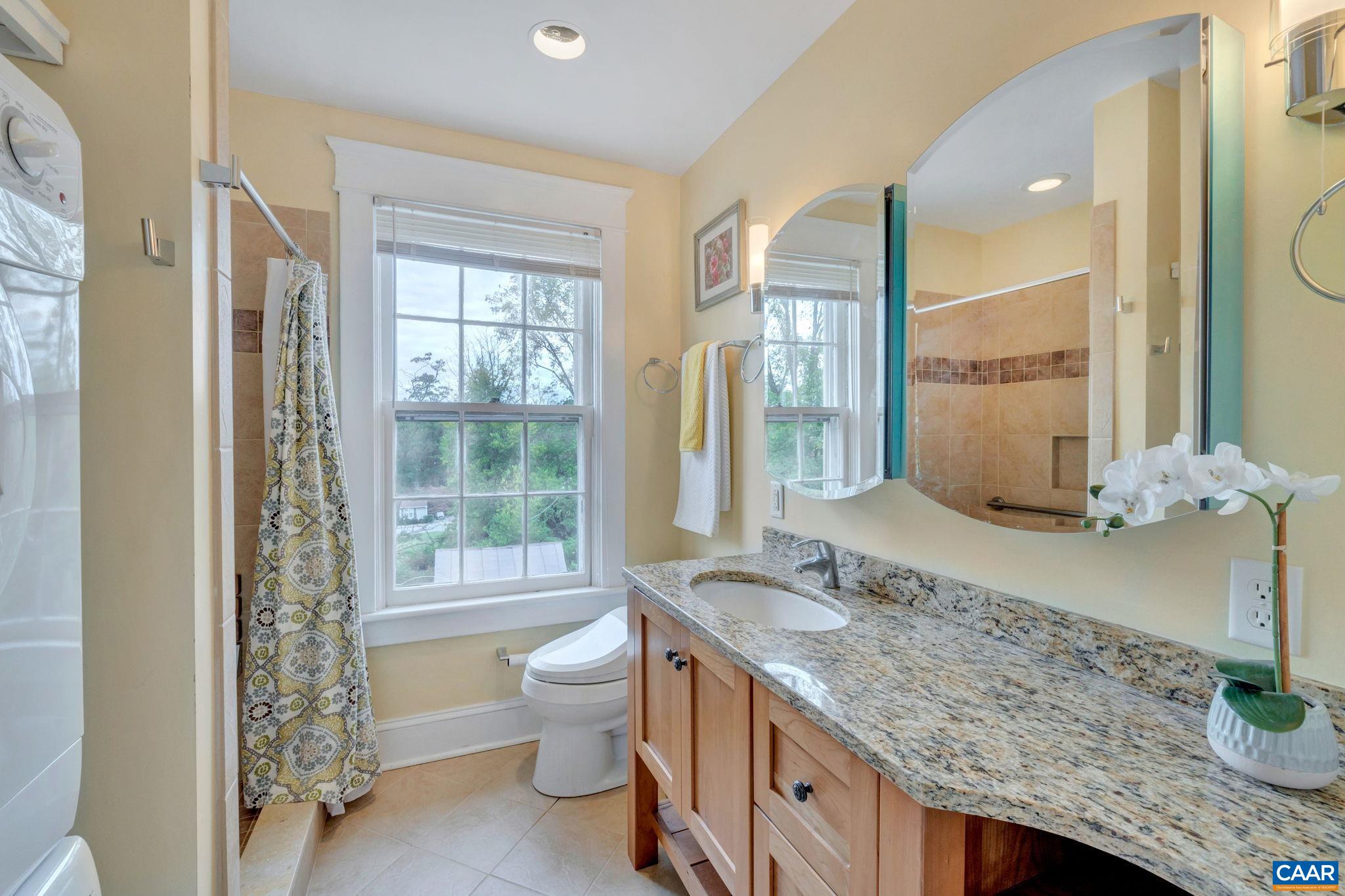 945 Locust Avenue Charlottesville, VA 22901 - Photo 28 of 52 a spacious bathroom with a granite countertop sink and a mirror