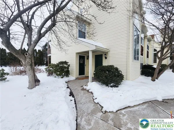 a view of a house with a yard covered in snow