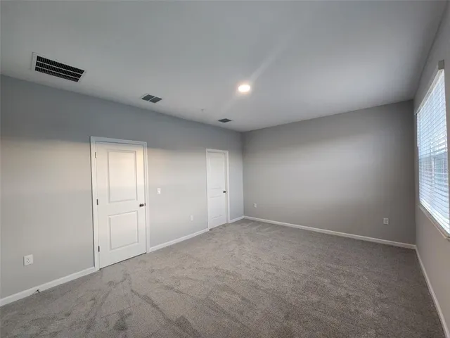 an empty room with windows and closet