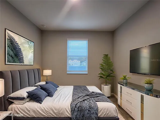 a bedroom with a bed and a flat screen tv