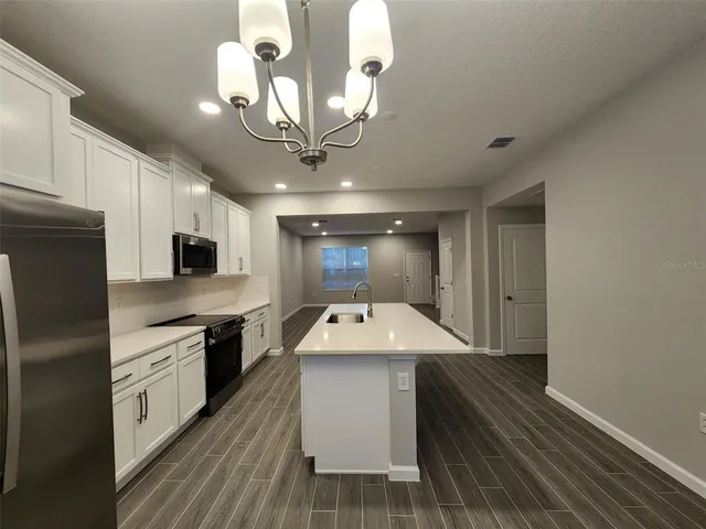 a kitchen with kitchen island granite countertop a sink stainless steel appliances and cabinets