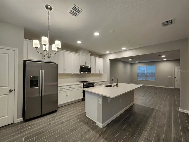 a kitchen with a stove a refrigerator and a sink