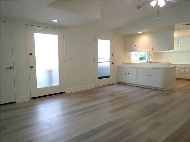 a view of a kitchen with wooden floor and window