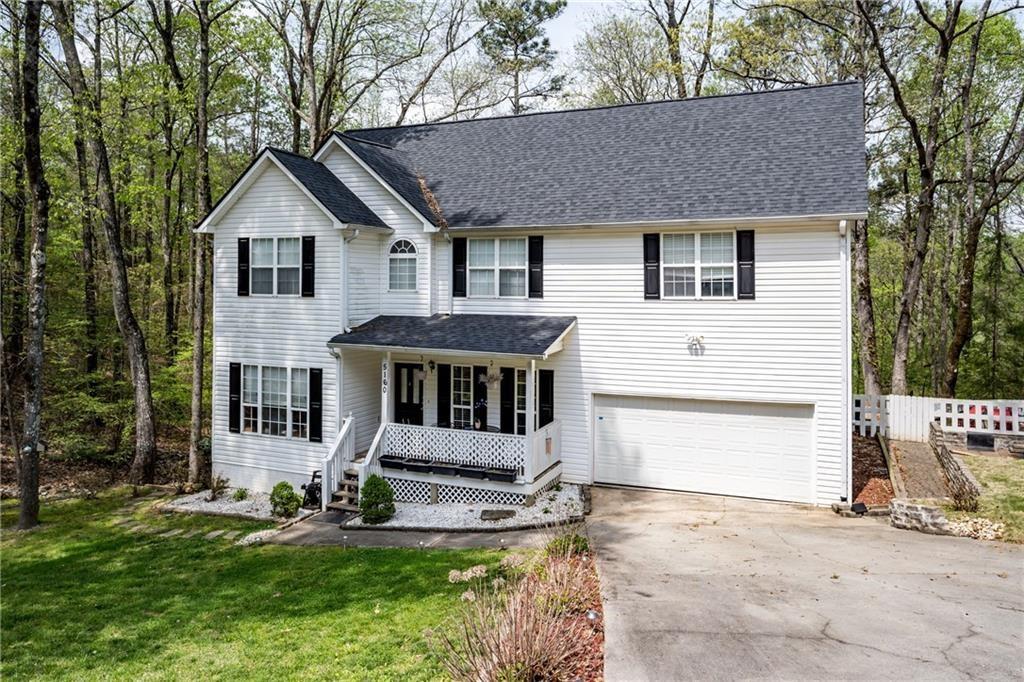 a front view of a house with a yard garage and chair