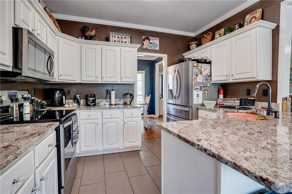 5160 Lakeview Parkway Villa Rica, GA 30180 - Photo 11 of 44 a kitchen with stainless steel appliances granite countertop a refrigerator sink and cabinets
