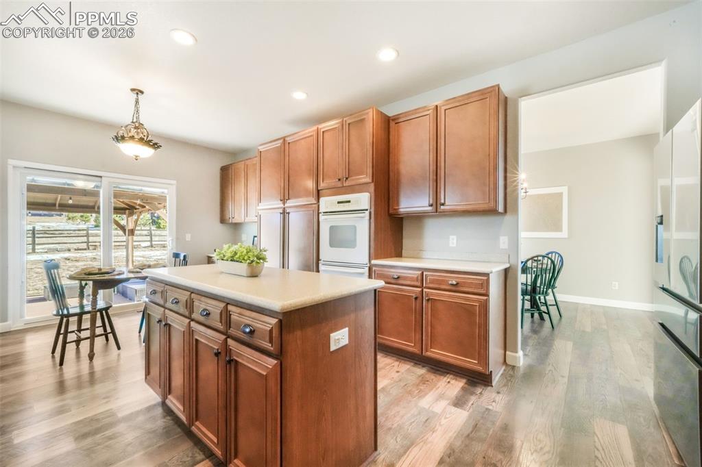 1675 Bowstring Road Monument, CO 80132 - Photo 14 of 50 a kitchen with kitchen island granite countertop a stove top oven a sink a dining table and chairs