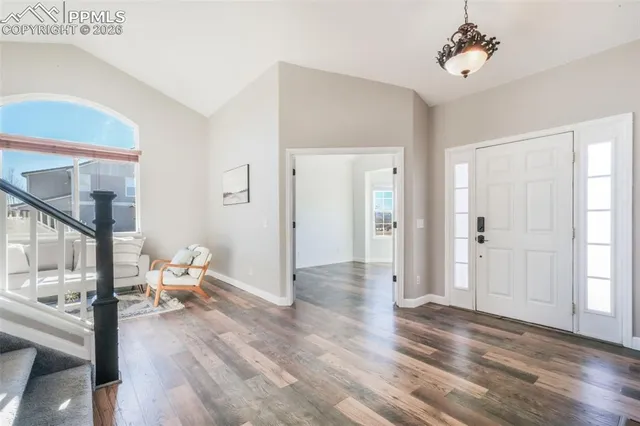 a view of a livingroom with wooden floor and a ceiling fan
