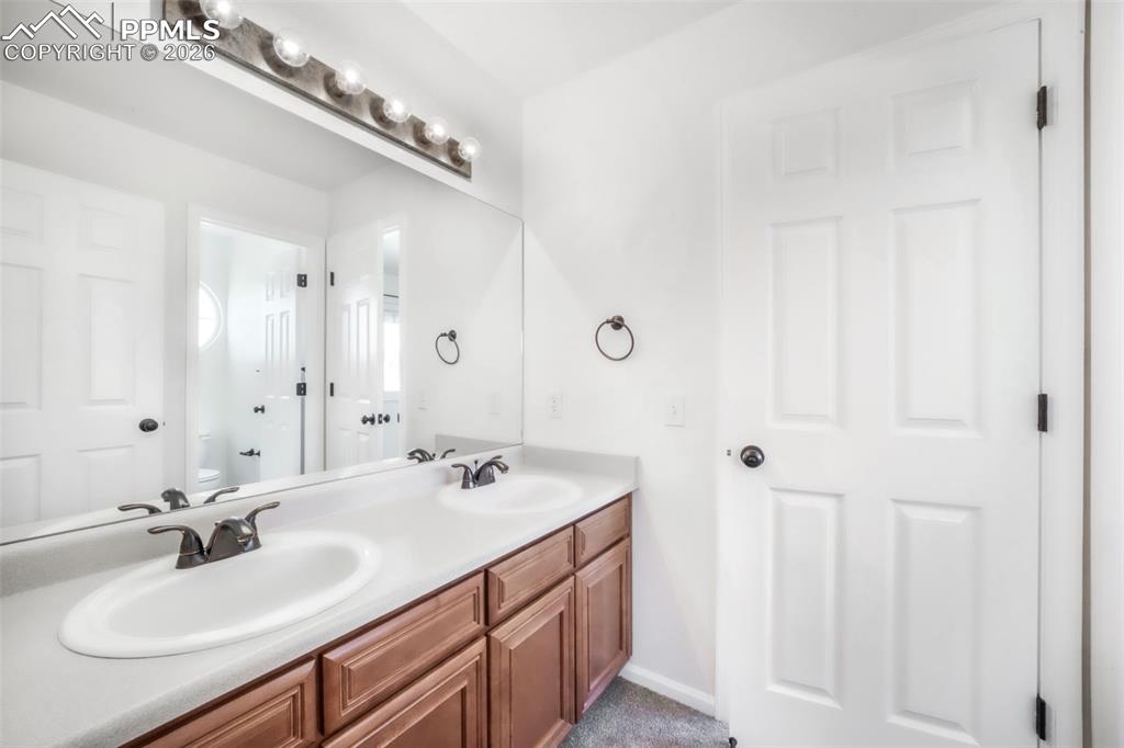 1675 Bowstring Road Monument, CO 80132 - Photo 31 of 50 a bathroom with a sink double vanity and a mirror