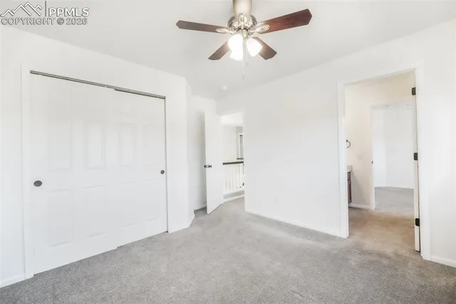 an empty room with a window and a ceiling fan