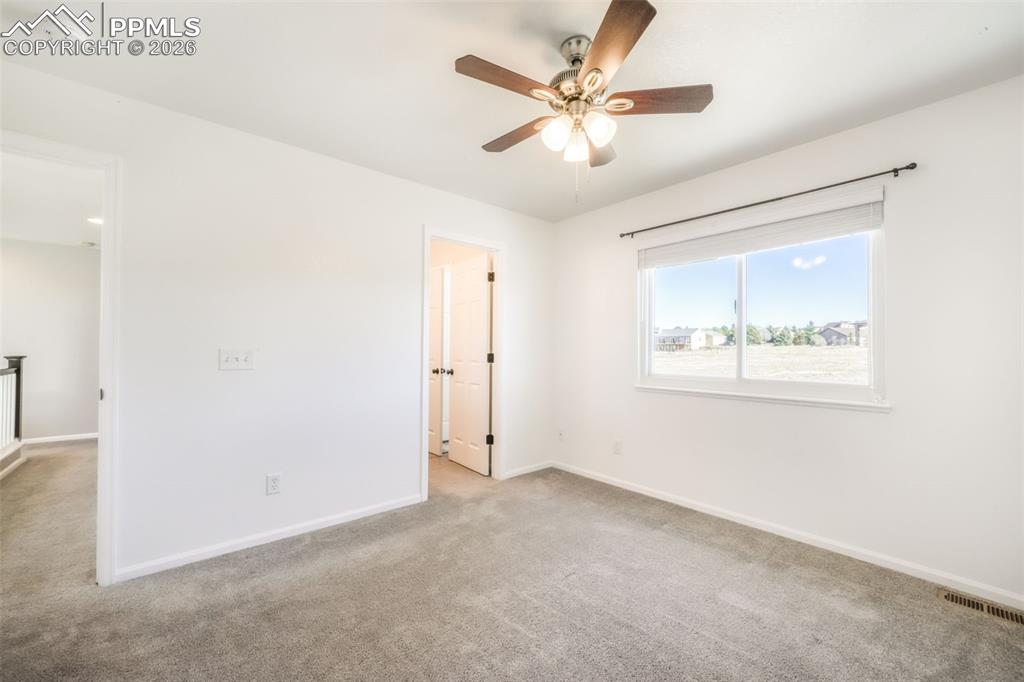 1675 Bowstring Road Monument, CO 80132 - Photo 33 of 50 an empty room with a window and a ceiling fan