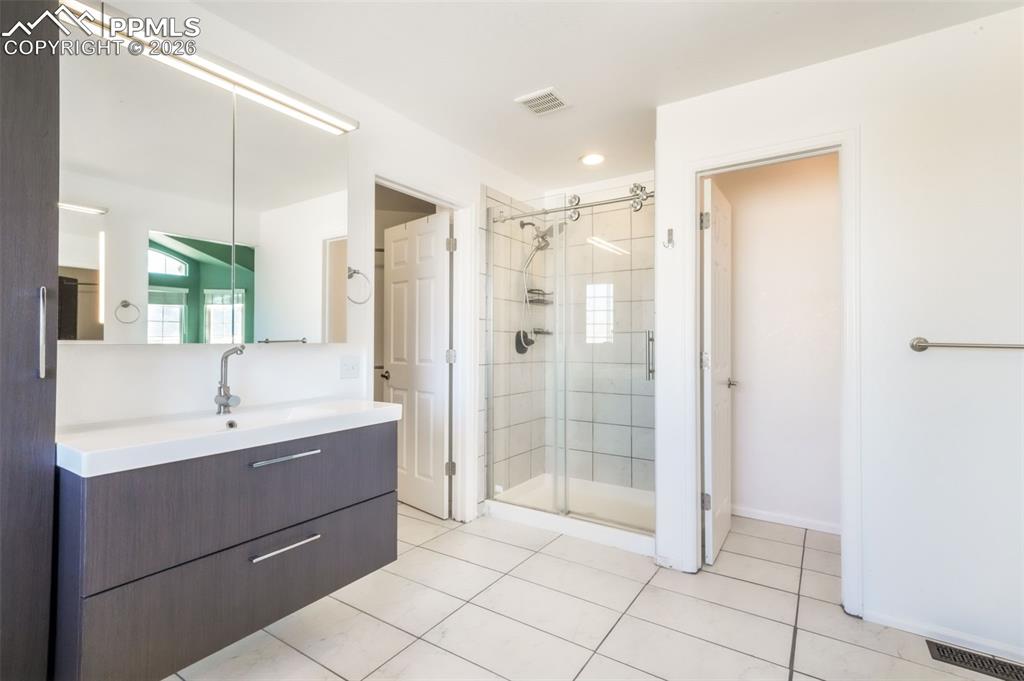 1675 Bowstring Road Monument, CO 80132 - Photo 40 of 50 a bathroom with a shower a sink and a mirror