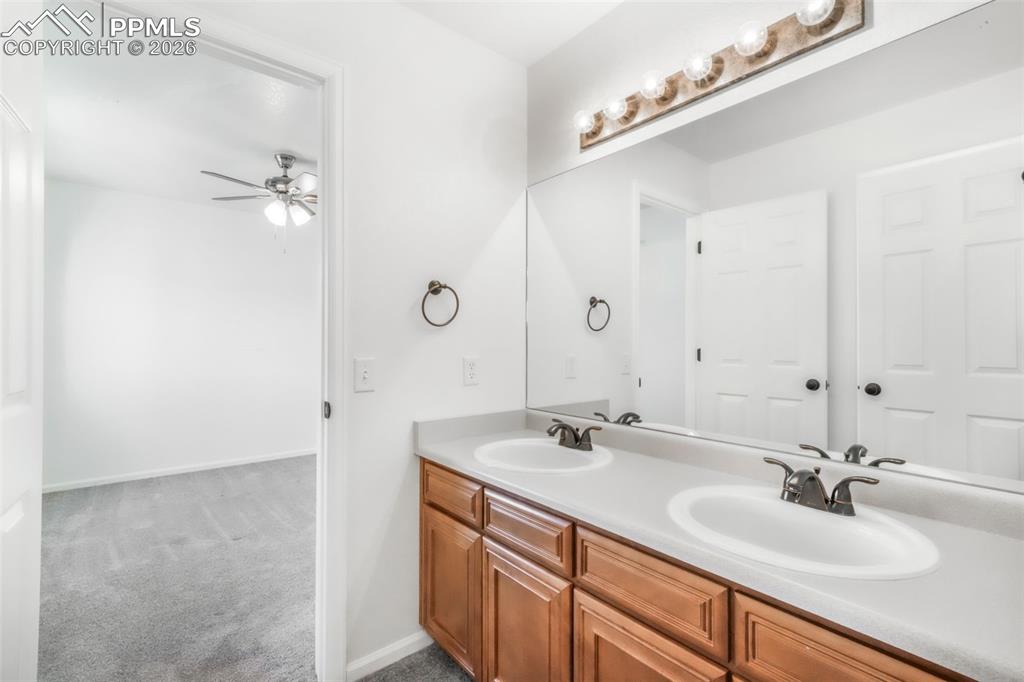 1675 Bowstring Road Monument, CO 80132 - Photo 43 of 50 a bathroom with a double vanity sink and mirror