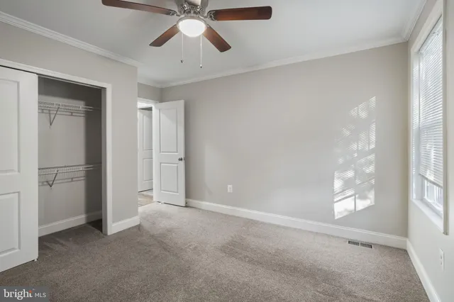 a view of empty room with window and ceiling fan