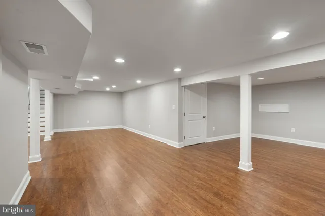 a view of empty room with wooden floor