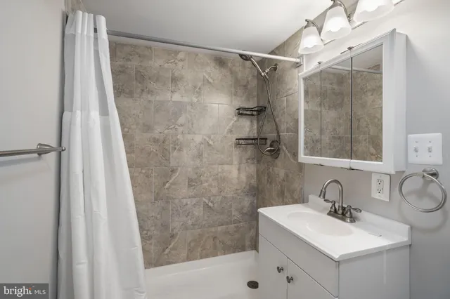 a bathroom with a sink mirror and shower