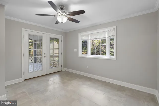 an empty room with windows and ceiling fan