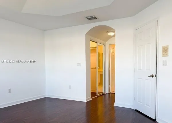 an empty room with wooden floor and a window