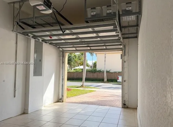 a view of water heater and a room with wooden floor