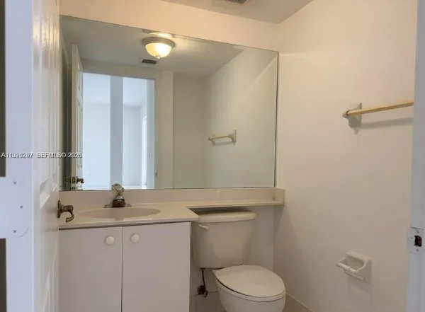 a bathroom with a granite countertop sink toilet and a mirror
