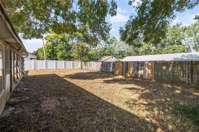 a view of a yard with wooden fence