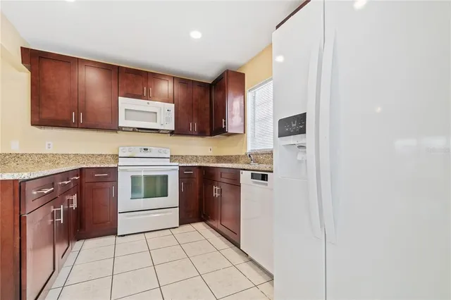 a kitchen with stainless steel appliances granite countertop a refrigerator stove and sink